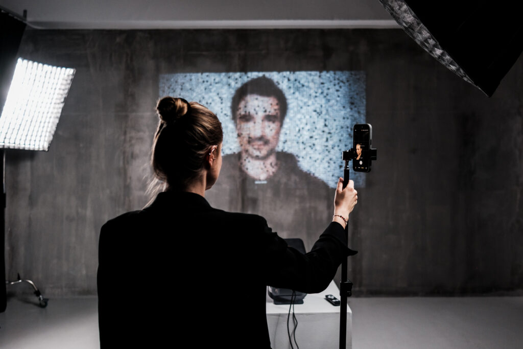 A visitor adds her photograph to the archive; the portrait rebuilds in real time